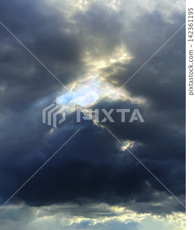 A spiritual, heavenly background image of a blue sky peeking through dark clouds. A spiritual, heavenly background image of a blue sky peeking through dark clouds. 142361195