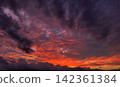 Purple clouds and a sky painted in the colors of the sunset 142361384