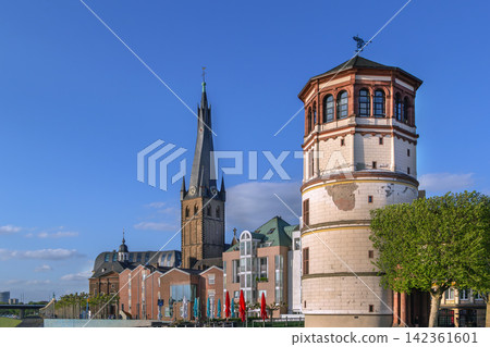 Old Castle Tower and St Lambertus church view from Rhine embankment in Dusseldorf Germany. Historic city architecture skyline Old Castle Tower and St Lambertus church view from Rhine embankment in Dusseldorf Germany. Historic city architecture skyline 142361601