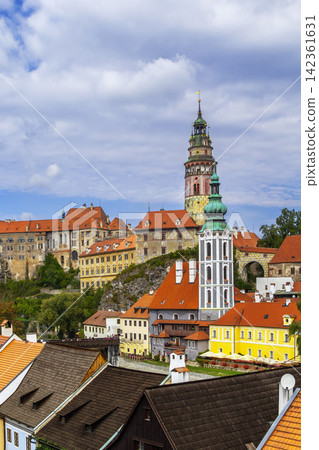 Cesky Krumlov view with castle tower across Vltava river in Czechia. Medieval town architecture under cloudy sky Cesky Krumlov view with castle tower across Vltava river in Czechia. Medieval town architecture under cloudy sky 142361631