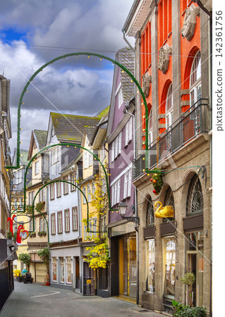 Cobblestone street in historical center of Wetzlar, Germany. No people on empty road under cloudy sky and overcast light Cobblestone street in historical center of Wetzlar, Germany. No people on empty road under cloudy sky and overcast light 142361756