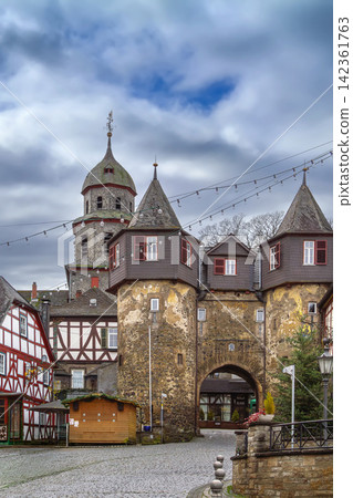 Historic city gate tower in Braunfels old town, Germany. Ancient stone archway with church tower under cloudy sky, no people Historic city gate tower in Braunfels old town, Germany. Ancient stone archway with church tower under cloudy sky, no people 142361763