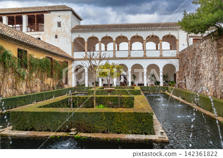 Ancient Court of the Sultana with water pools in Generalife gardens, Granada, Spain. Historic architecture under cloudy sky Ancient Court of the Sultana with water pools in Generalife gardens, Granada, Spain. Historic architecture under cloudy sky 142361822