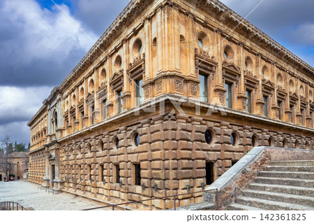Renaissance Palace of Charles V facade in Alhambra fortress of Granada, Spain. Stone architecture under cloudy overcast sky 142361825