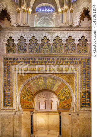 Mihrab of Mosque Cathedral of Cordoba, Spain. Famous moorish horse-shoe arch with golden mosaic ornaments, indoor light Mihrab of Mosque Cathedral of Cordoba, Spain. Famous moorish horse-shoe arch with golden mosaic ornaments, indoor light 142361874