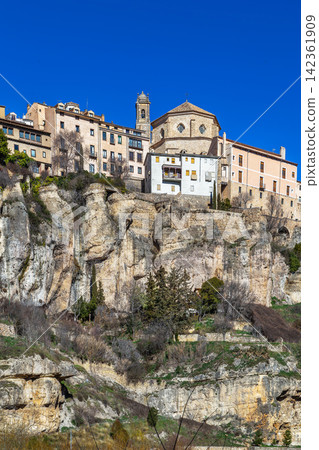 View of Cuenca historical center and Cathedral from Huecar River canyon, Spain. Medieval city on rocks under blue sky, no people View of Cuenca historical center and Cathedral from Huecar River canyon, Spain. Medieval city on rocks under blue sky, no people 142361909