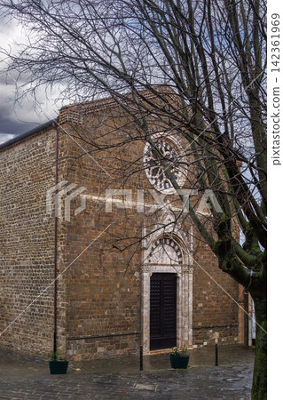 Sant Agostino church in Montalcino Italy front facade view. Gothic architecture during rainy overcast day Sant Agostino church in Montalcino Italy front facade view. Gothic architecture during rainy overcast day 142361969