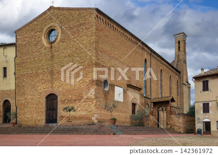 Sant Agostino church in San Gimignano Italy side view of the apse. Romanesque architecture under overcast cloudy sky Sant Agostino church in San Gimignano Italy side view of the apse. Romanesque architecture under overcast cloudy sky 142361972