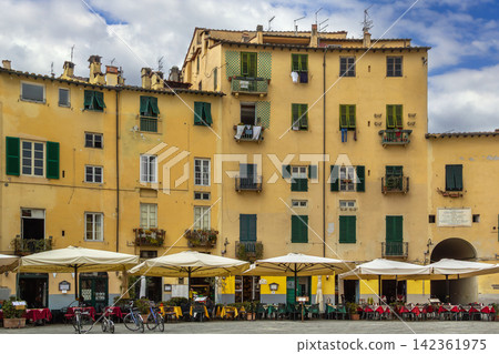 Piazza Anfiteatro in Lucca Italy view of the square. Medieval architecture under overcast cloudy sky Piazza Anfiteatro in Lucca Italy view of the square. Medieval architecture under overcast cloudy sky 142361975