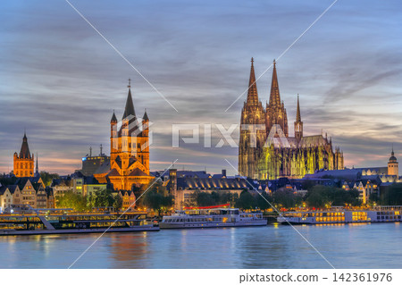 Cologne historical center with cathedral and Saint Martin view at evening from Rhine in Germany. Illuminated city architecture Cologne historical center with cathedral and Saint Martin view at evening from Rhine in Germany. Illuminated city architecture 142361976