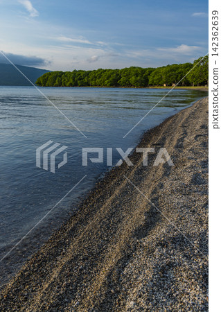 從日本北海道倭子利町屈斜路湖沙浴的足浴池周圍可以看到湖泊及其湖岸的景色。 從日本北海道倭子利町屈斜路湖沙浴的足浴池周圍可以看到湖泊及其湖岸的景色。 142362639