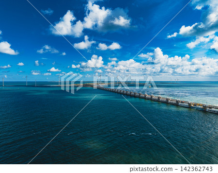 High angle wide horizontal aerial drone photograph of Eastern Scheldt storm surge barrier, wind turbines, sea water, and cloudy blue sky at Neeltje Jans, Zeeland, Netherlands on sunny summer day High angle wide horizontal aerial drone photograph of Eastern Scheldt storm surge barrier, wind turbines, sea water, and cloudy blue sky at Neeltje Jans, Zeeland, Netherlands on sunny summer day 142362743