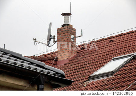 Satellite Dish and Brick Chimney on Tiled House Roof Satellite Dish and Brick Chimney on Tiled House Roof 142362990