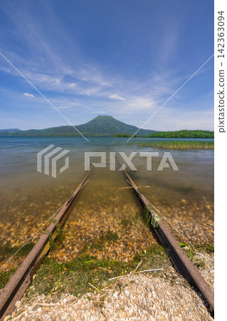 日本,北海道,釧路市:阿寒湖綠意盎然,阿寒山,以及湖畔鐵路的景色。 日本,北海道,釧路市:阿寒湖綠意盎然,阿寒山,以及湖畔鐵路的景色。 142363094