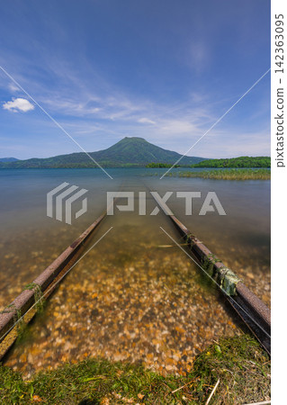 日本,北海道,釧路市:阿寒湖綠意盎然,阿寒山,以及湖畔鐵路的景色。 日本,北海道,釧路市:阿寒湖綠意盎然,阿寒山,以及湖畔鐵路的景色。 142363095
