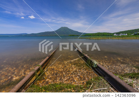 日本,北海道,釧路市:阿寒湖綠意盎然,阿寒山,以及湖畔鐵路的景色。 日本,北海道,釧路市:阿寒湖綠意盎然,阿寒山,以及湖畔鐵路的景色。 142363096