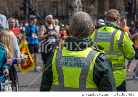 Paramedics monitoring marathon runners on city street Paramedics monitoring marathon runners on city street 142363426