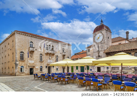 Town hall and clock tower on central square in Trogir, Croatia. Outdoor cafe tables under bright daytime sky Town hall and clock tower on central square in Trogir, Croatia. Outdoor cafe tables under bright daytime sky 142363534