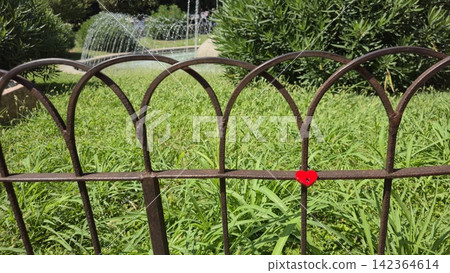 A heart-shaped lock on a fence near a fountain in central Verona, Italy. Concepts of tourism, love, expressions of affection, European tours, Valentine's Day A heart-shaped lock on a fence near a fountain in central Verona, Italy. Concepts of tourism, love, expressions of affection, European tours, Valentine's Day 142364614