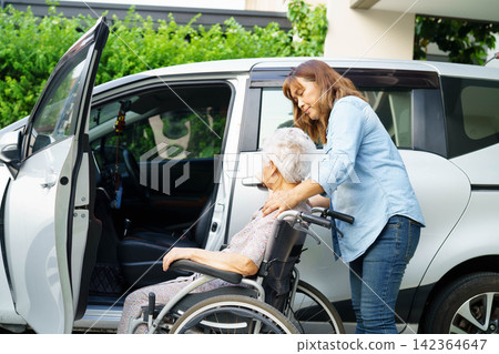 Caregiver help Asian elderly woman disability patient use wheelchair to get in car. Caregiver help Asian elderly woman disability patient use wheelchair to get in car. 142364647