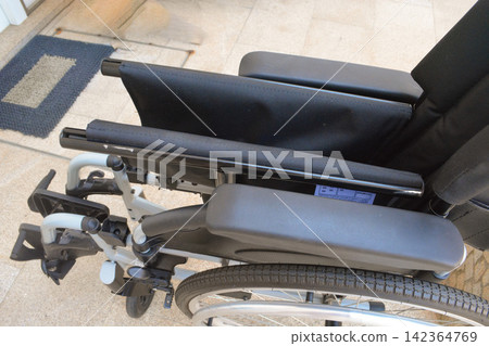 Person installing a pressure relief wheelchair cushion on a mobility chair in an accessible setting. Concepts: accessibility, healthcare, disability, mobility, rehabilitation, comfort. Person installing a pressure relief wheelchair cushion on a mobility chair in an accessible setting. Concepts: accessibility, healthcare, disability, mobility, rehabilitation, comfort. 142364769
