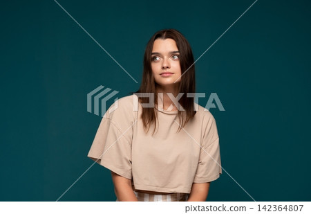 Young woman thinking, looking away, reflecting on thoughts with a serious expression and copy space Young woman thinking, looking away, reflecting on thoughts with a serious expression and copy space 142364807