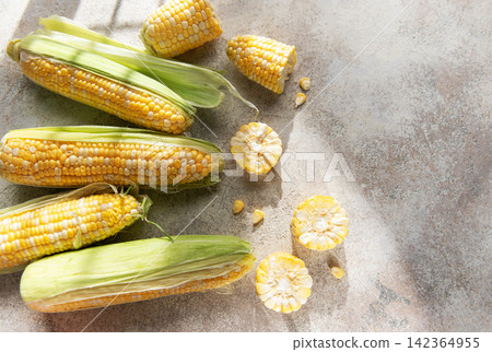 Fresh organic corn cobs and kernels on rustic background Fresh organic corn cobs and kernels on rustic background 142364955