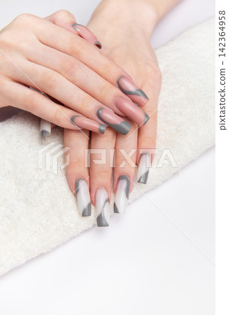 Woman's hands showing long gray and white nails Woman's hands showing long gray and white nails 142364958