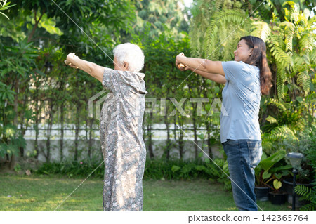 Asian elderly woman disability patient exercise on wheelchair with doctor in park, medical concept. Asian elderly woman disability patient exercise on wheelchair with doctor in park, medical concept. 142365764
