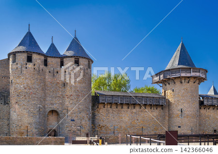 Courtyard of Cite de Carcassonne in France, facing the towers. Medieval castle fortress architecture under clear daylight Courtyard of Cite de Carcassonne in France, facing the towers. Medieval castle fortress architecture under clear daylight 142366046