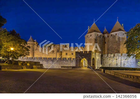 Evening view of Cite de Carcassonne in France, showing the illuminated main entrance. Medieval fortress architecture at dusk Evening view of Cite de Carcassonne in France, showing the illuminated main entrance. Medieval fortress architecture at dusk 142366056