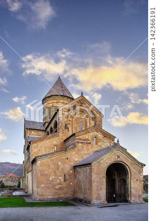 Ancient Svetitskhoveli Cathedral stands in historic Mtskheta, Georgia. Front facade view in warm evening sunset light Ancient Svetitskhoveli Cathedral stands in historic Mtskheta, Georgia. Front facade view in warm evening sunset light 142366191