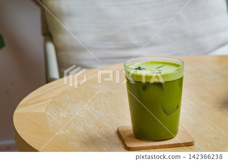freshness vivid green iced matcha on wood table with green ornamental plant in cafe freshness vivid green iced matcha on wood table with green ornamental plant in cafe 142366238