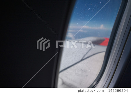view from a window of air plane when flying on the cloud with air plane's wing outside view from a window of air plane when flying on the cloud with air plane's wing outside 142366294