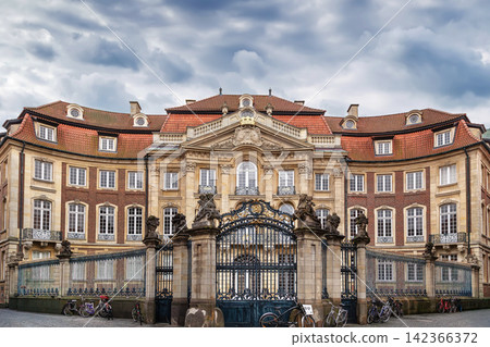 Erbdrostenhof palace, Munster, Germany, view across fence. Elegant late baroque architecture building under daytime sky Erbdrostenhof palace, Munster, Germany, view across fence. Elegant late baroque architecture building under daytime sky 142366372