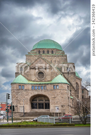 Old Synagogue in Essen, Germany, front view. Historic art nouveau and Byzantine style architecture under cloudy winter sky without snow Old Synagogue in Essen, Germany, front view. Historic art nouveau and Byzantine style architecture under cloudy winter sky without snow 142366419