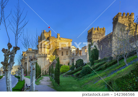 Royal Palace of Olite, Spain, view from Paseo de Dona Leonor gardens. Gothic castle walls with medieval towers and green park Royal Palace of Olite, Spain, view from Paseo de Dona Leonor gardens. Gothic castle walls with medieval towers and green park 142366566