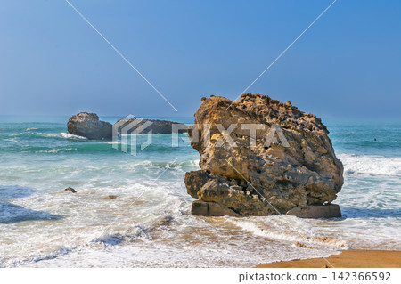 Rocks on the Bay of Biscay in Biarritz, France. Sunny daylight with blue sky. Atlantic ocean coast Rocks on the Bay of Biscay in Biarritz, France. Sunny daylight with blue sky. Atlantic ocean coast 142366592