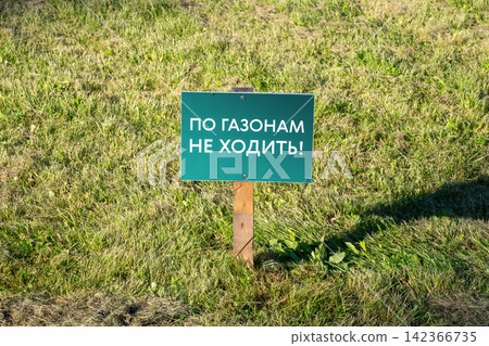 Green Restrictive Lawn Sign on Grass with Russian Text "Do Not Walk on Lawns" 142366735