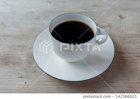 一杯熱咖啡倒入白色杯子中——這是咖啡館或休息時間的畫面。 一杯熱咖啡倒入白色杯子中——這是咖啡館或休息時間的畫面。 142366823