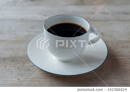一杯熱咖啡倒入白色杯子中——這是咖啡館或休息時間的畫面。 一杯熱咖啡倒入白色杯子中——這是咖啡館或休息時間的畫面。 142366824