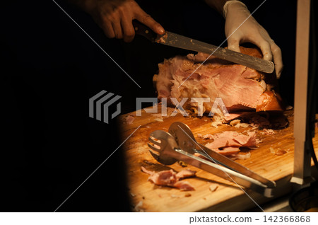 a man cut a roasted chicken on wood cutting board ready to served for dinner party reception a man cut a roasted chicken on wood cutting board ready to served for dinner party reception 142366868