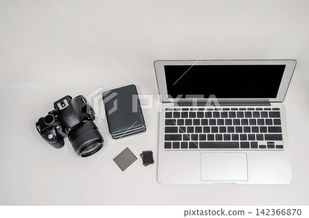 a laptop with digital camera and storage on table in white background a laptop with digital camera and storage on table in white background 142366870