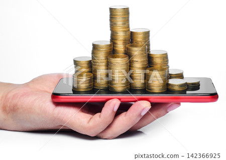 a hand holding smartphone with stack of many coins put on the screen represent about e-commerce, investment, cryptocurrency, mobile financial, internet banking, online payment, and electronic wallet. a hand holding smartphone with stack of many coins put on the screen represent about e-commerce, investment, cryptocurrency, mobile financial, internet banking, online payment, and electronic wallet. 142366925