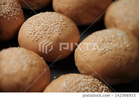 many baked sesame topping burger breads lay on oven tray waiting for cooking, shot with shallow focusing and tilted lens effect for background wallpaper many baked sesame topping burger breads lay on oven tray waiting for cooking, shot with shallow focusing and tilted lens effect for background wallpaper 142366933