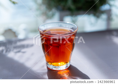 Tea poured into a clear glass – an image of a cafe or a break time. 142366961
