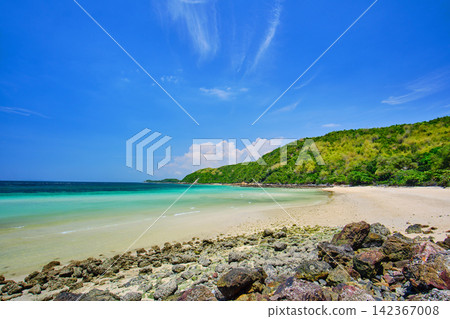 rocky shore and a sandy beach on the island with blue-green sea and clear blue sky rocky shore and a sandy beach on the island with blue-green sea and clear blue sky 142367008