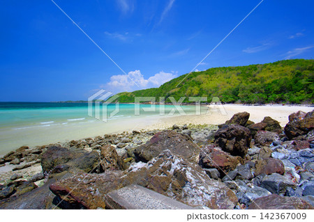 rocky shore and a sandy beach on the island with blue-green sea and clear blue sky rocky shore and a sandy beach on the island with blue-green sea and clear blue sky 142367009