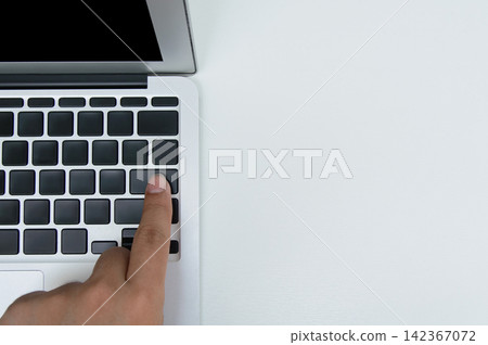 a hand with Index finger touch on computer keyboard's blank black color key on white background a hand with Index finger touch on computer keyboard's blank black color key on white background 142367072