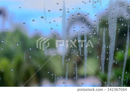 rain drops during raining in rainy day outside window glass with blurred background with water droplet flow down the surface rain drops during raining in rainy day outside window glass with blurred background with water droplet flow down the surface 142367084